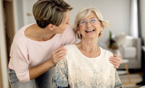 Caregiver hugging and laughing with client