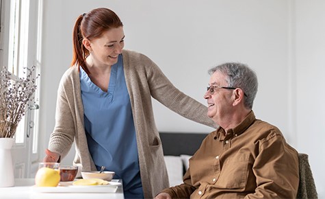 Caregiver enjoying a morning laugh at breakfast with her client.